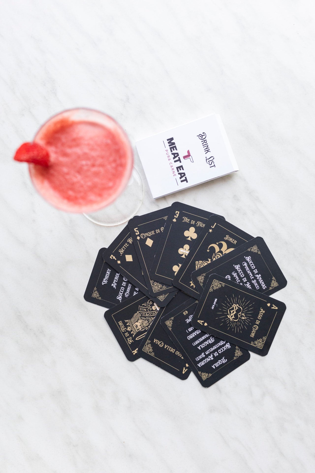 La drink list di Meat Eat su tavolo di marmo con calice